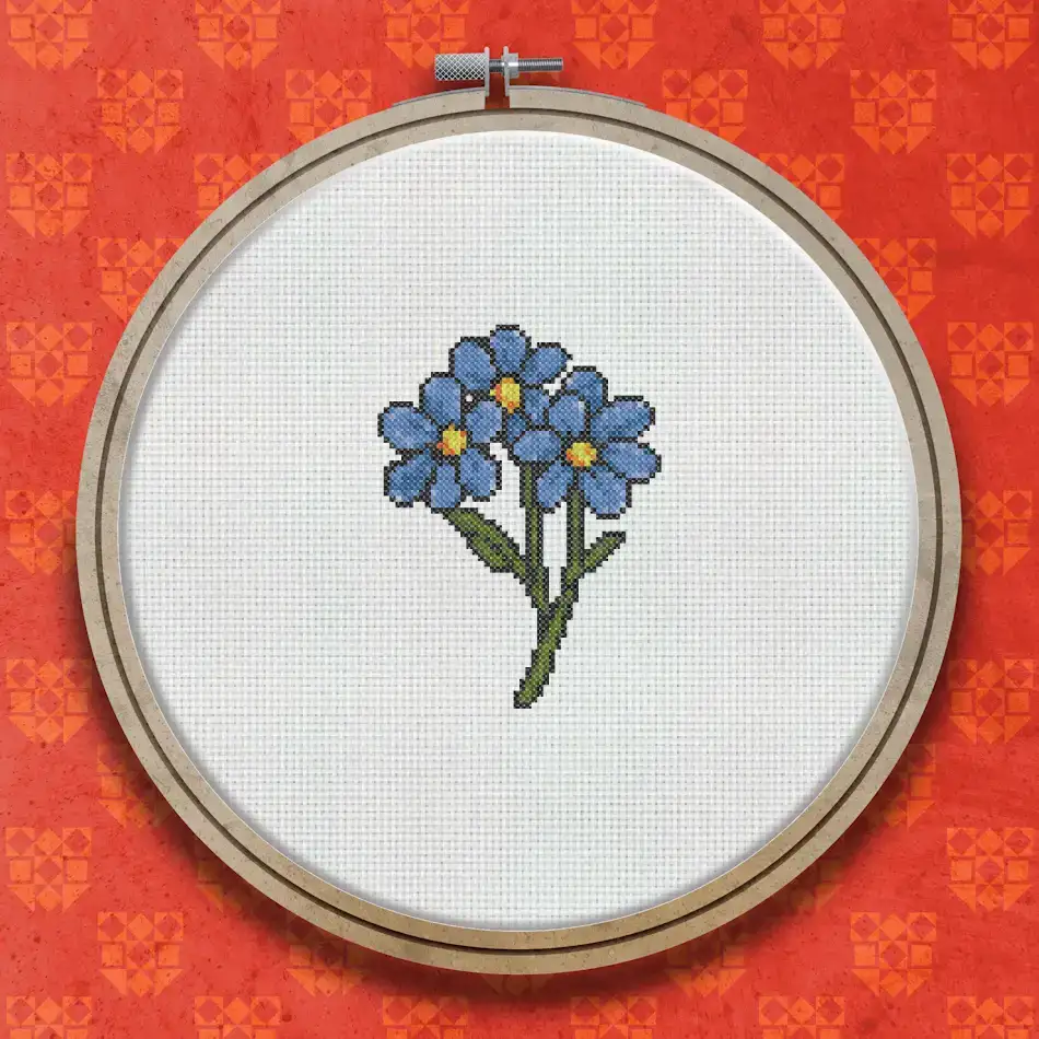 Cross stitch design of three blue forget-me-not flowers with yellow centres on green stems and leaves against a white background.