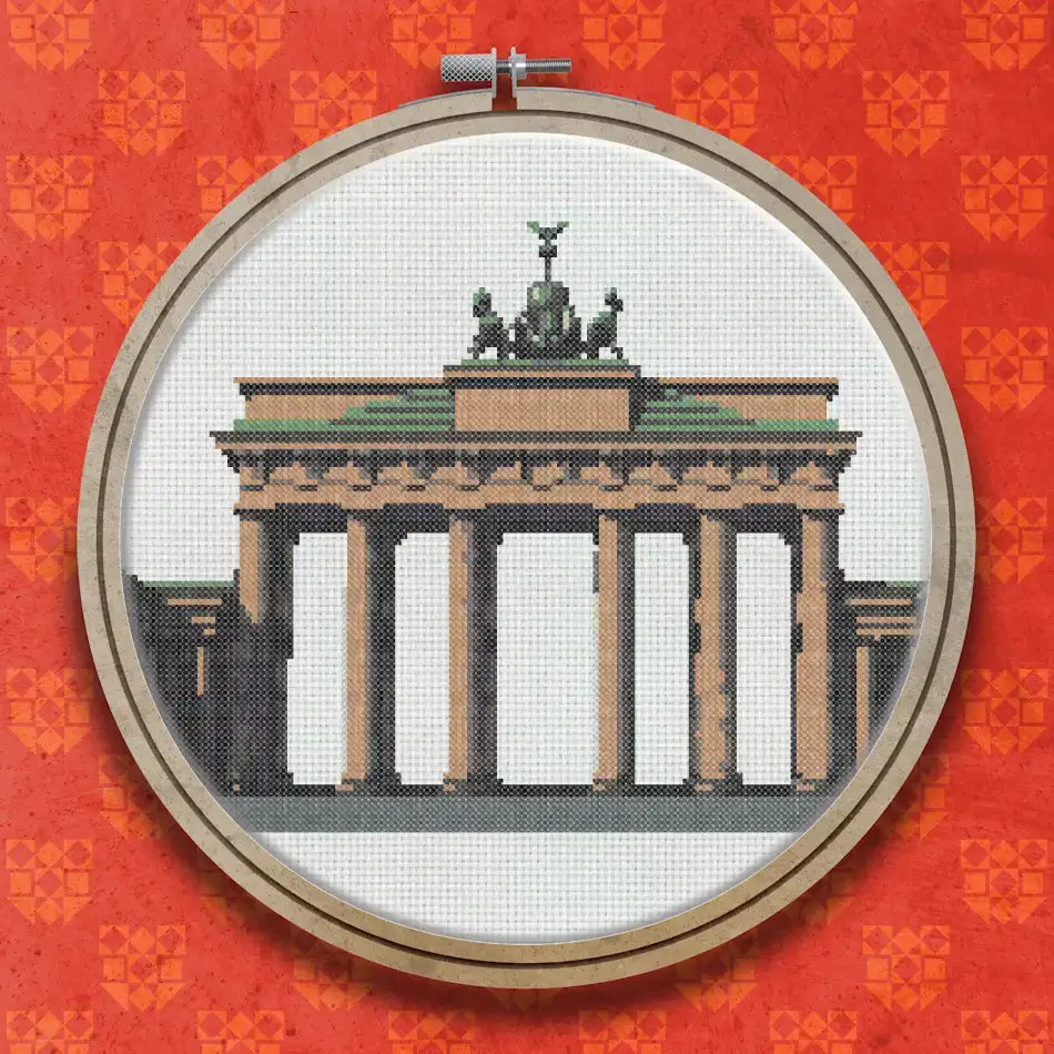 Cross stitch design of the Brandenburg Gate showing six columns, a green entablature, and a chariot sculpture on top against a light background.