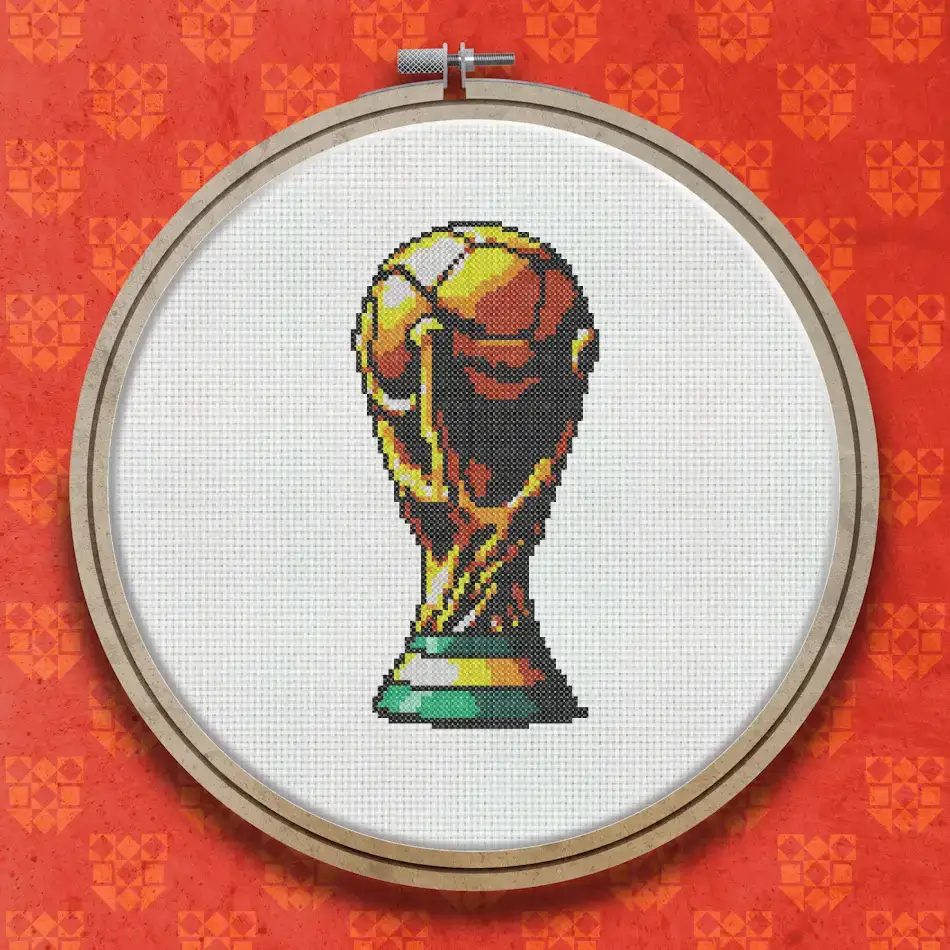 Cross stitch design of the FIFA World Cup trophy in shades of gold and yellow on a dark background, showing the full trophy with figurine base and globe top.