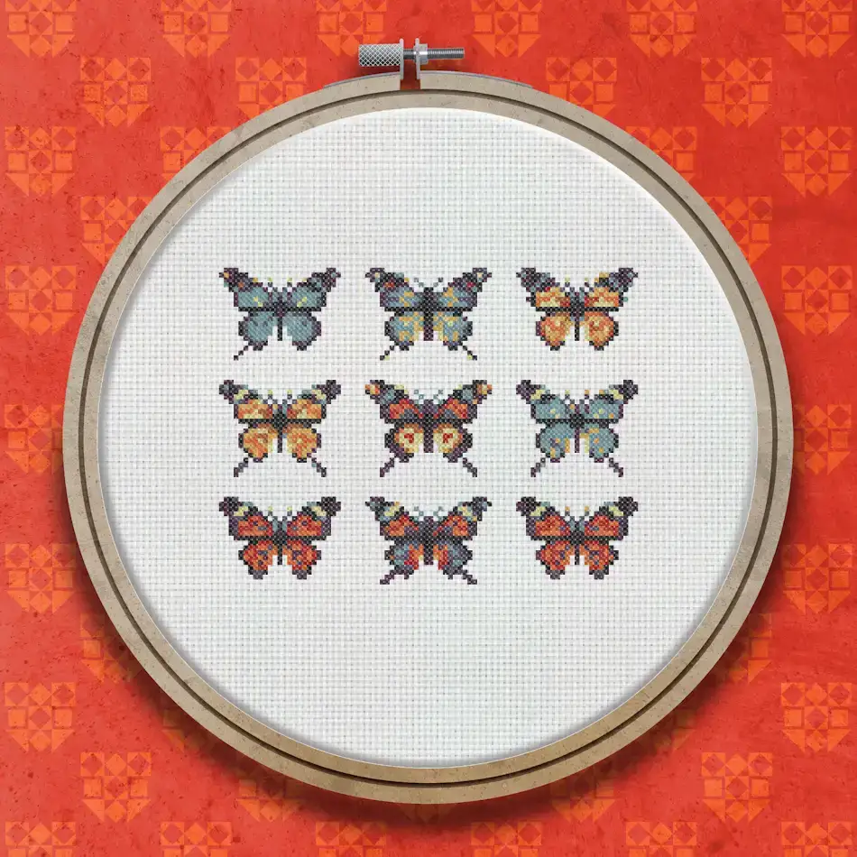 Nine cross stitch butterflies arranged in a three-by-three grid, each in different colour combinations including orange, red, blue, and cream on a white background.