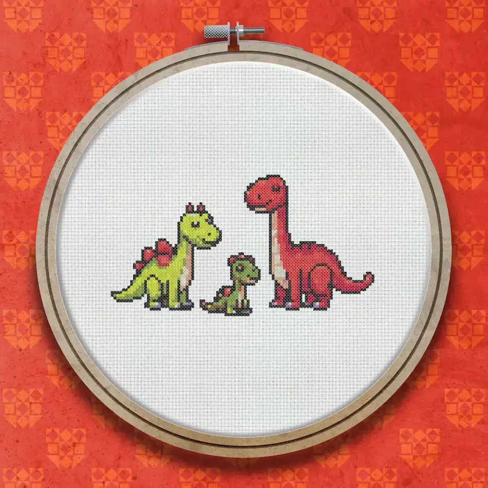 Cross stitch pattern of three dinosaurs: a red long-necked dinosaur, a small green dinosaur, and a larger green stegosaurus-like dinosaur on a white background.