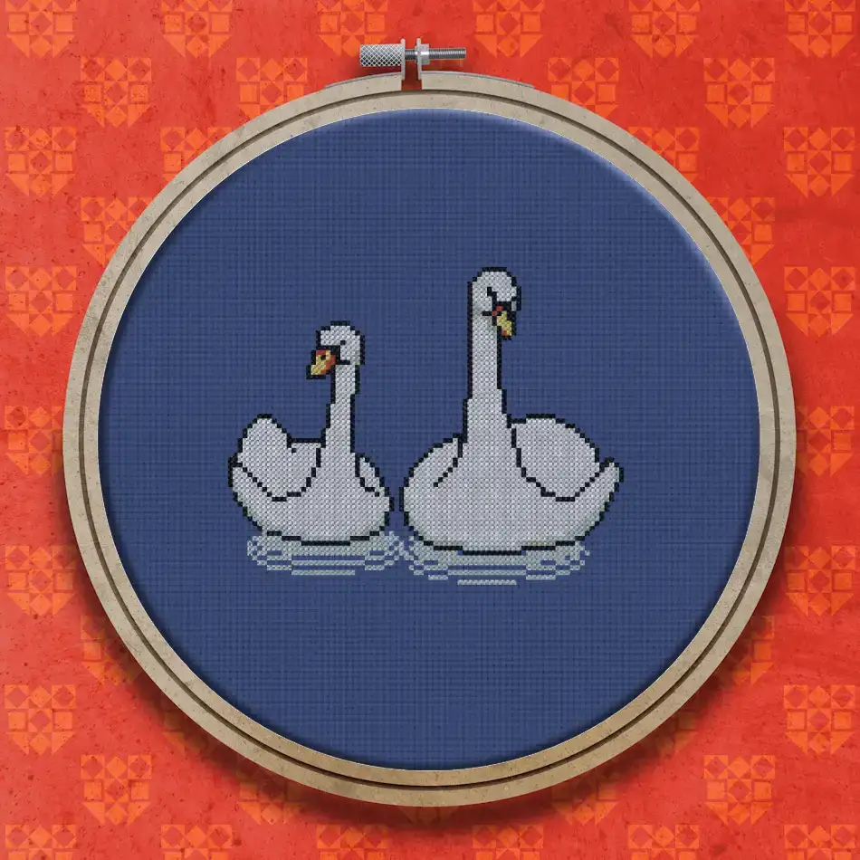 Cross stitch design of two white swans sitting side by side, each with an orange beak, facing slightly inward.