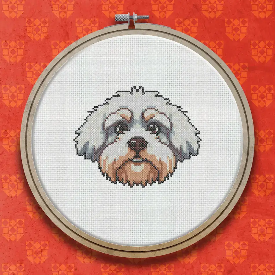 Cross stitch design of a fluffy white Maltese dog with a round face, dark eyes, and a small nose, shown as a close-up portrait.