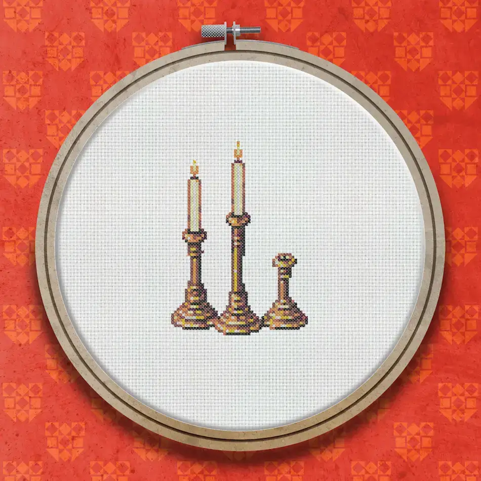Cross stitch design of three wooden candlesticks of different heights, each holding a lit candle with a yellow flame, in warm brown and gold tones.