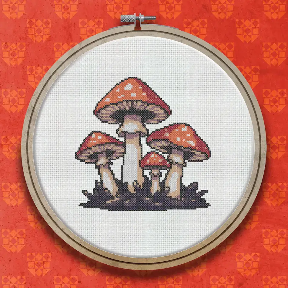 Cross stitch design of a group of red and white spotted toadstools with brown stems clustered together on a dark grassy base
