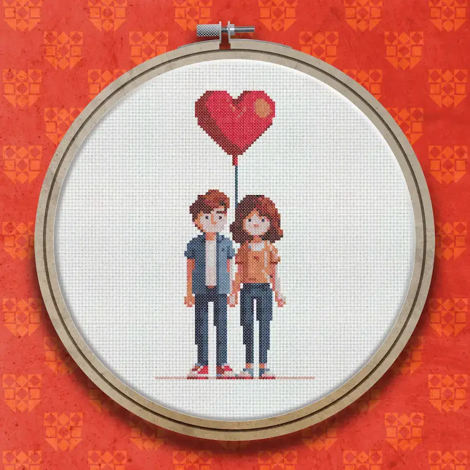 Cross stitch design of a young couple standing together, the man in a grey top and blue jeans, the woman in an orange top, with a large red heart-shaped balloon above them.