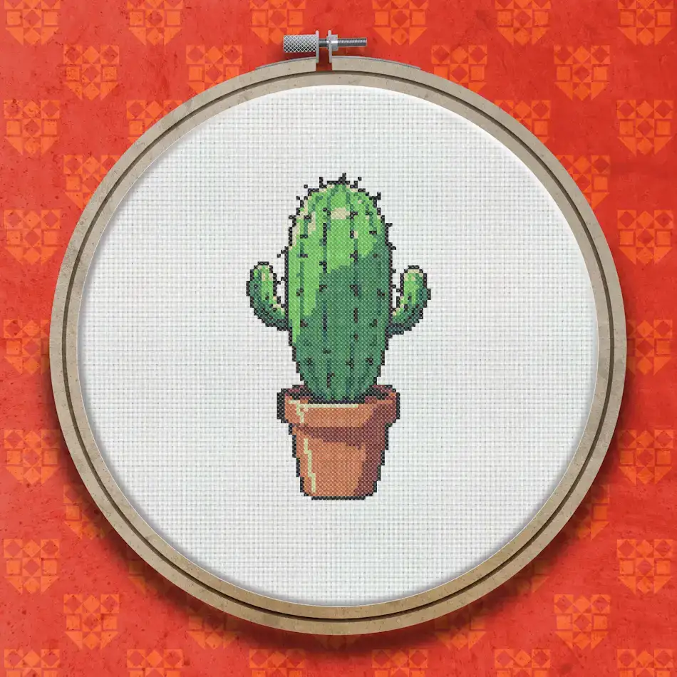 Cross stitch pattern of a green cactus with spines growing in a small terracotta pot, shown against a white background.