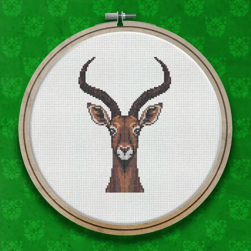 Cross stitch portrait of an antelope head with long curved horns, warm brown colouring, and a white muzzle on a plain background.