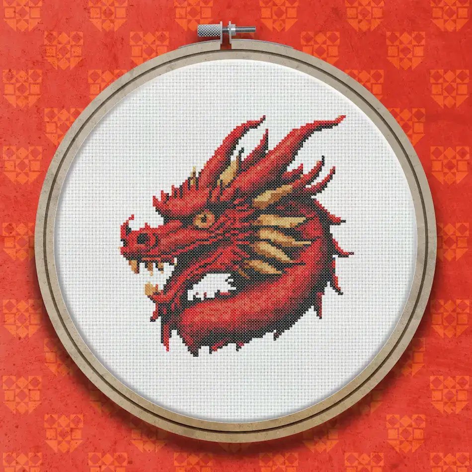 Finished cross stitch of a red dragon head facing forward with open mouth, glowing red and orange tones, detailed scales and fierce expression