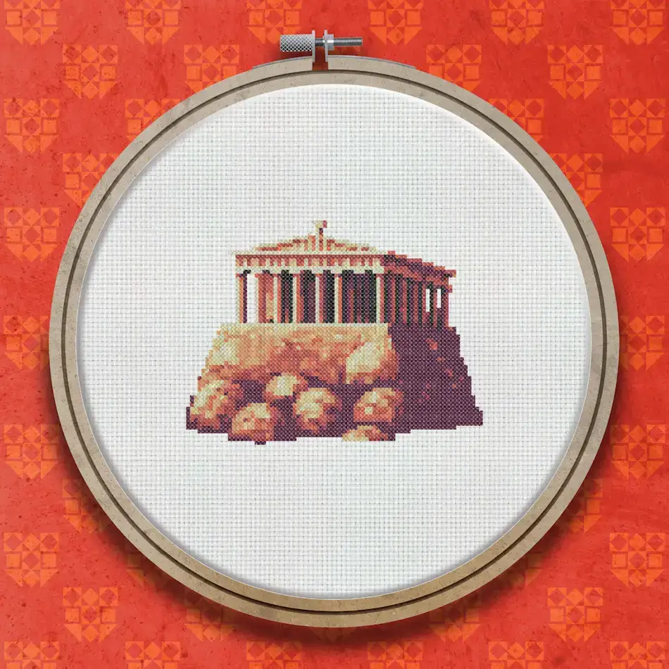 Cross stitch design of a classical Greek temple with columns on a rocky hill base, rendered in warm terracotta, golden and grey tones.
