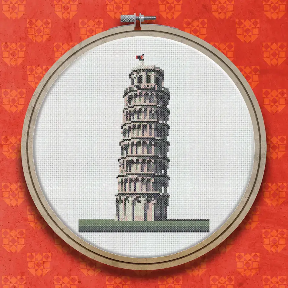Cross stitch design of the Leaning Tower of Pisa showing the white multi-tiered cylindrical tower leaning to the right, with a small flag at the top and green grass at the base.