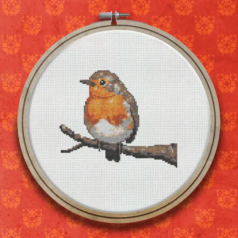 Cross stitch pattern of a robin with a bright orange-red breast perched on a brown branch against a white background.