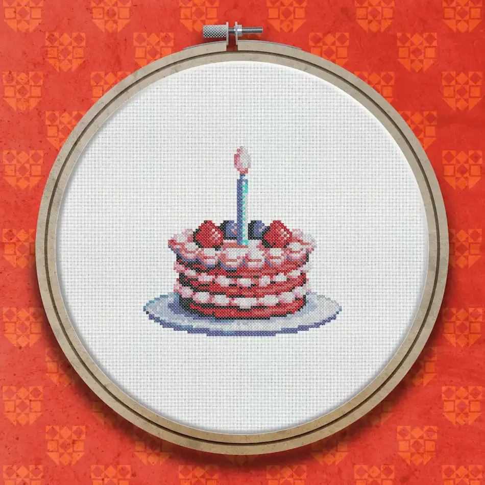 Cross stitch design of a layered birthday cake with white cream filling, red berry decorations, and a single lit candle on top.