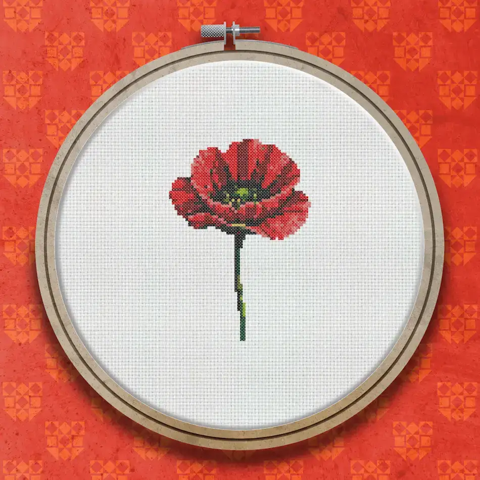 Cross stitch pattern of a red poppy flower with dark centre and green stem against a white background.