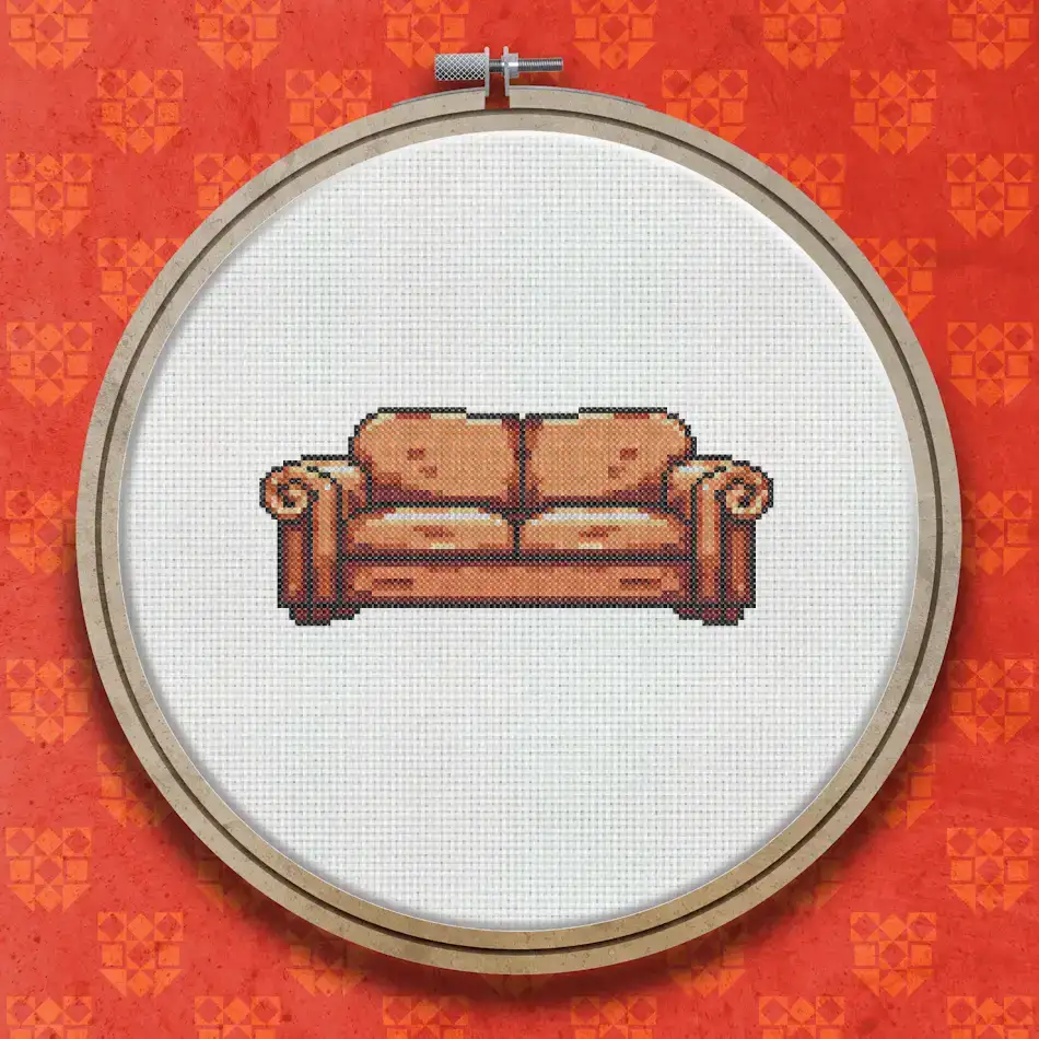 Cross stitch pattern of a brown upholstered retro two-seater sofa with rounded arms, shown in warm earthy tones on a light background.