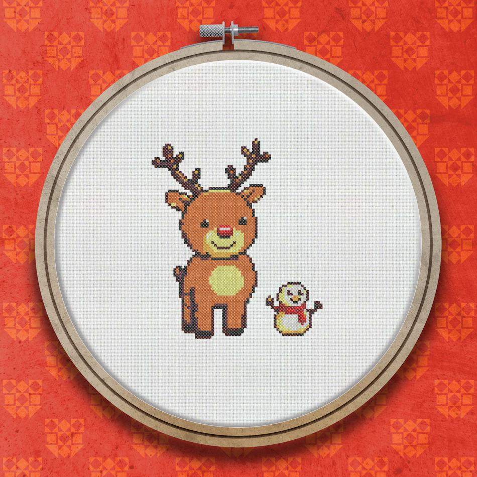 Cross stitch design showing a brown reindeer with antlers standing beside a small white snowman with a yellow beak and pink cheeks on a white background.