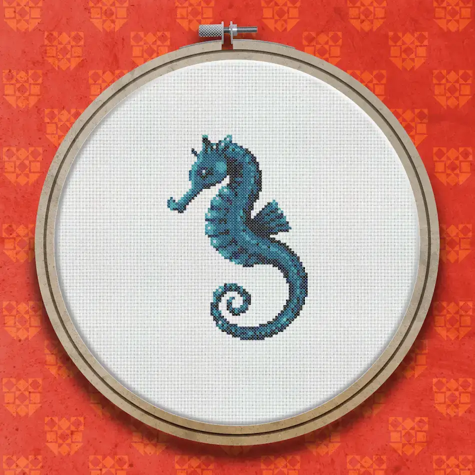 Cross stitch pattern of a seahorse in shades of teal and blue, shown in profile with a curled tail and detailed segmented body.