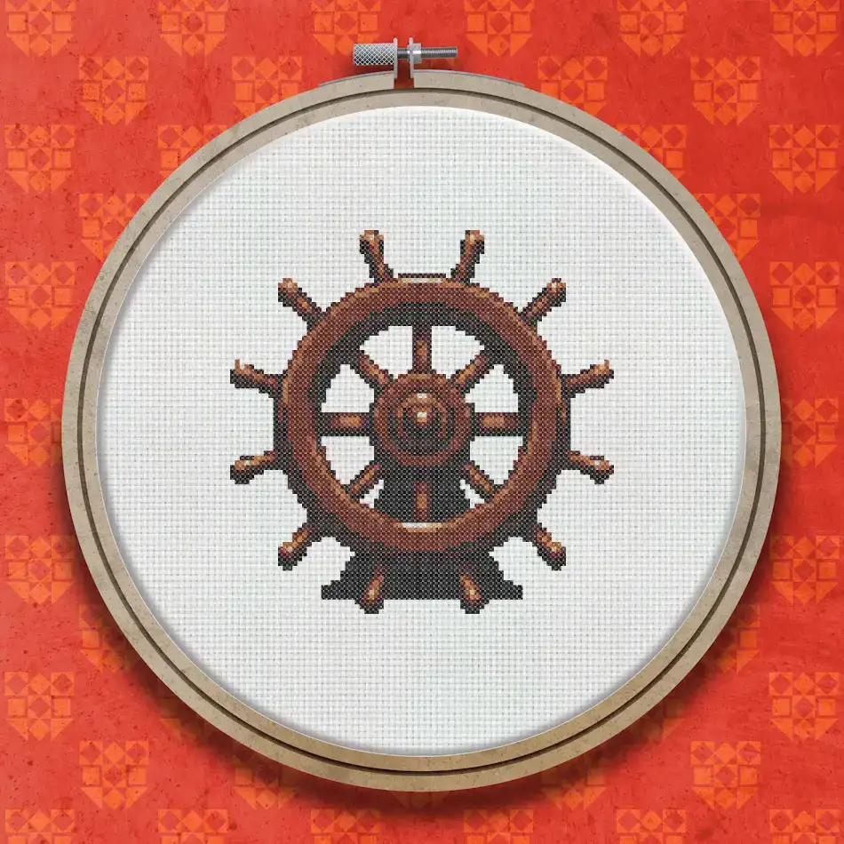 A circular ships wheel cross stitch design with eight spokes, stitched in rich dark brown and warm mid-brown tones on a light background.