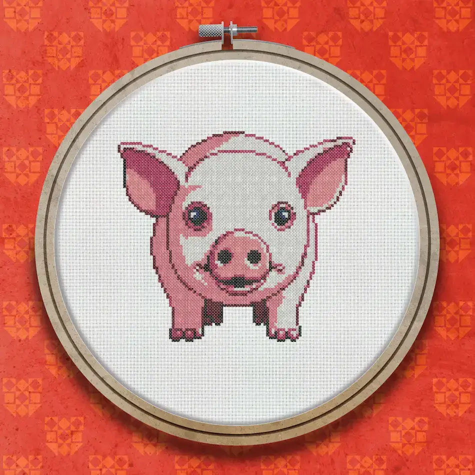 Cross stitch design of a small pink pig facing forward with rosy cheeks, a pink snout, dark eyes, and small ears against a white background.