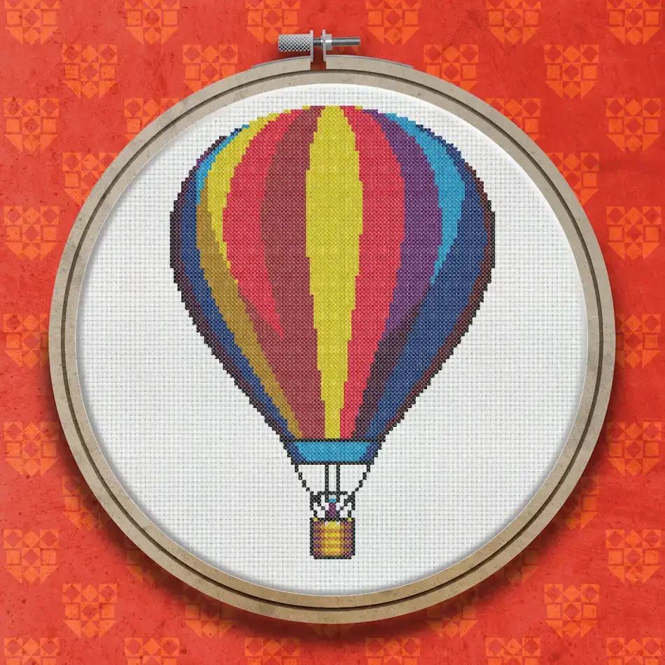 Cross stitch design of a striped hot air balloon in red, yellow, orange, blue and purple with a small wicker basket beneath it.