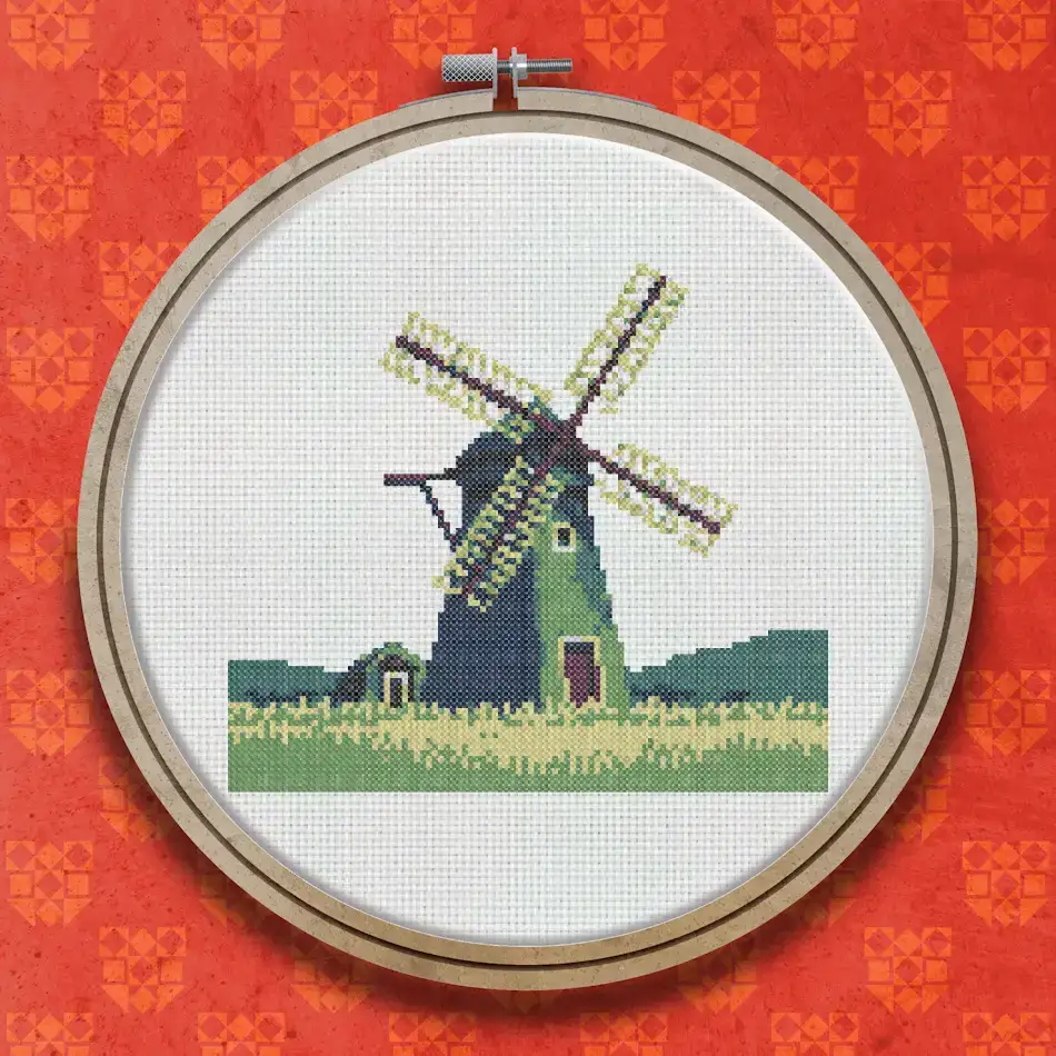 Cross stitch design of a traditional green and brown windmill with four sails, standing in a green field under a blue sky.