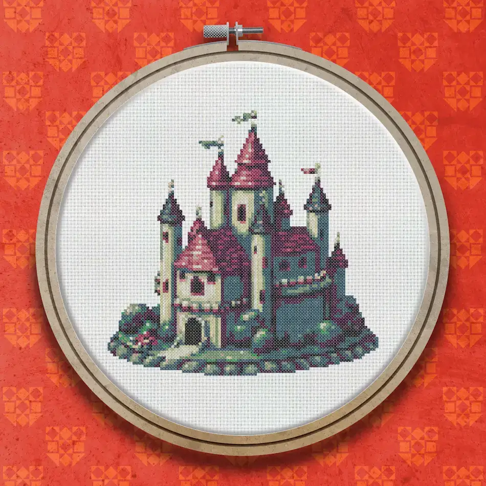 Cross stitch castle with pink and grey stone towers, pointed turrets with red flags, arched entrance, and rocky base on a white background.