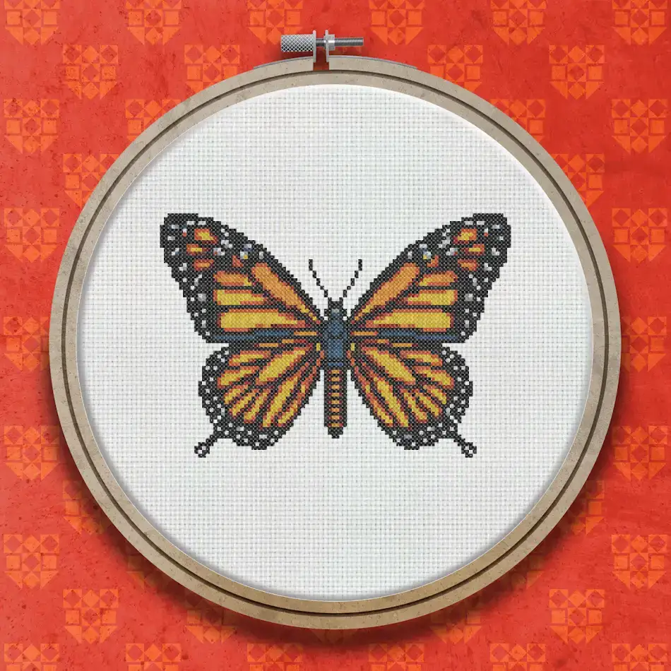 Cross stitch pattern of a monarch butterfly with orange wings, black veining and white spotted borders, viewed from above with wings fully spread.