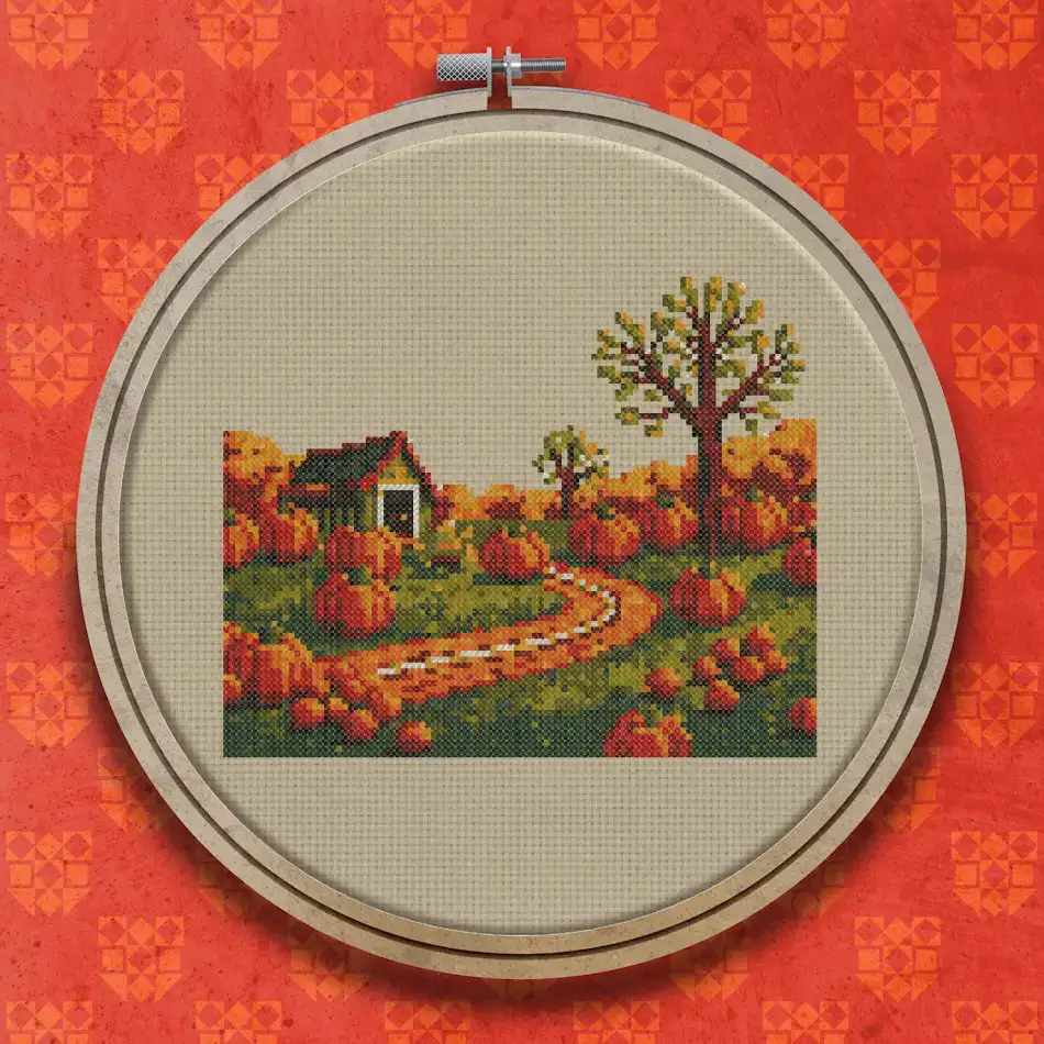 Cross stitch of a small dark cottage surrounded by rows of orange pumpkins in a field, with bare trees and a winding path.