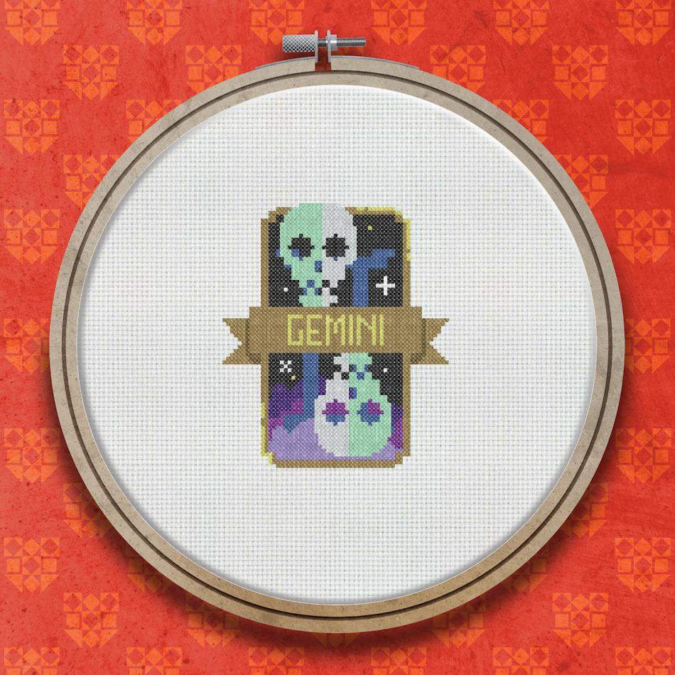 Cross stitch design showing two ghost-like twin figures on a dark background with purple and teal tones, framed by a decorative border with the word Gemini