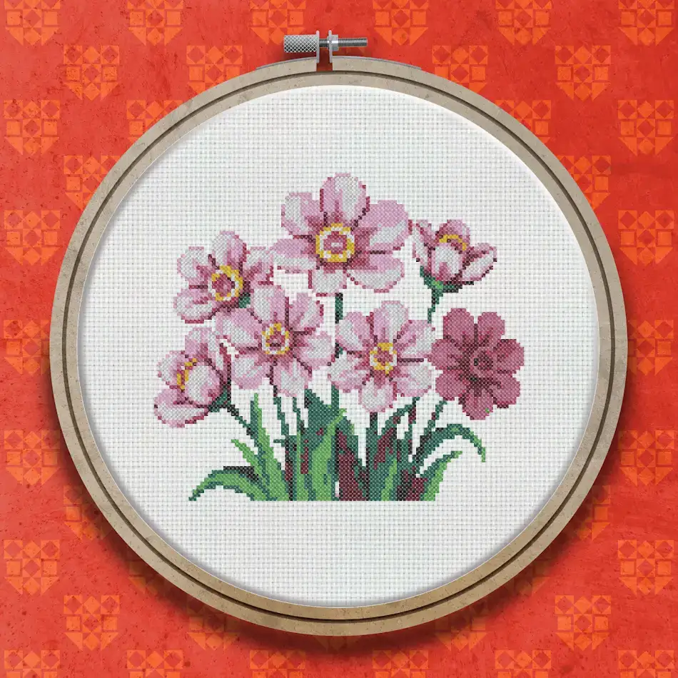 Cross stitch pattern of a cluster of soft pink five-petalled flowers with yellow centres and green leaves on stems
