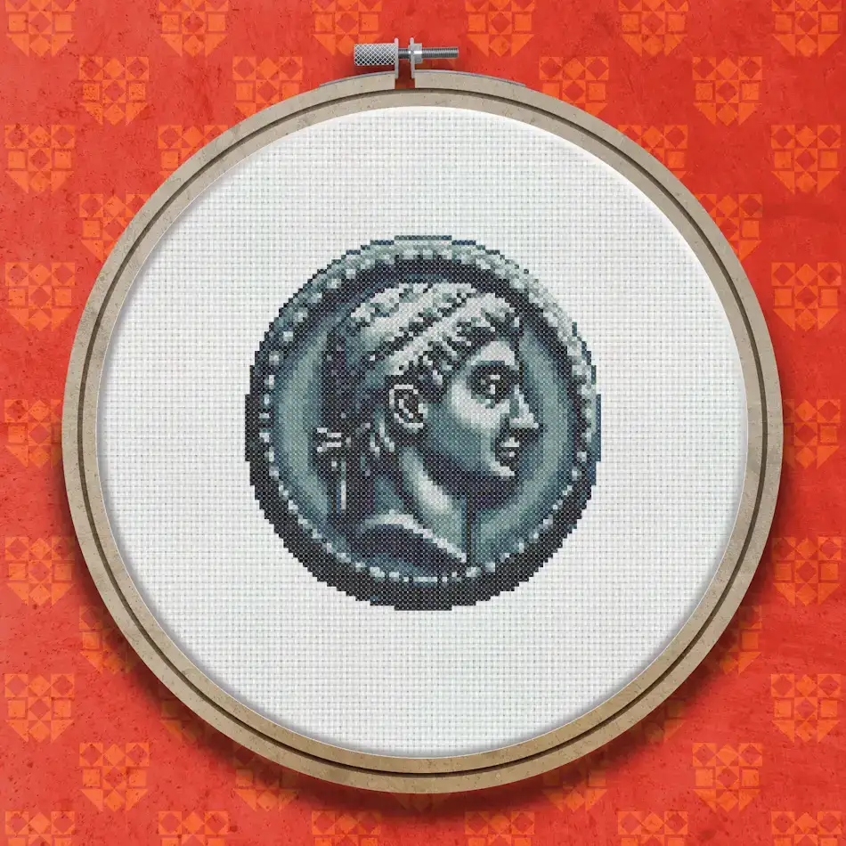 Cross stitch design of a silver Roman coin showing a classical profile portrait of a figure facing right, with a plain dark background.