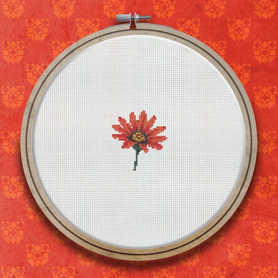 Cross stitch pattern of a single red flower with pointed petals and a small golden yellow centre on a white background.