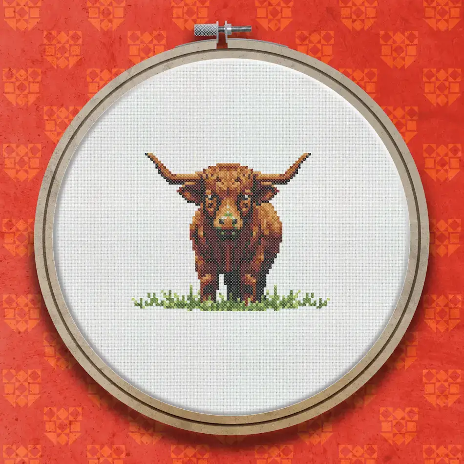 Cross stitch design of a shaggy brown Highland cow with long curved horns standing on a small patch of green grass