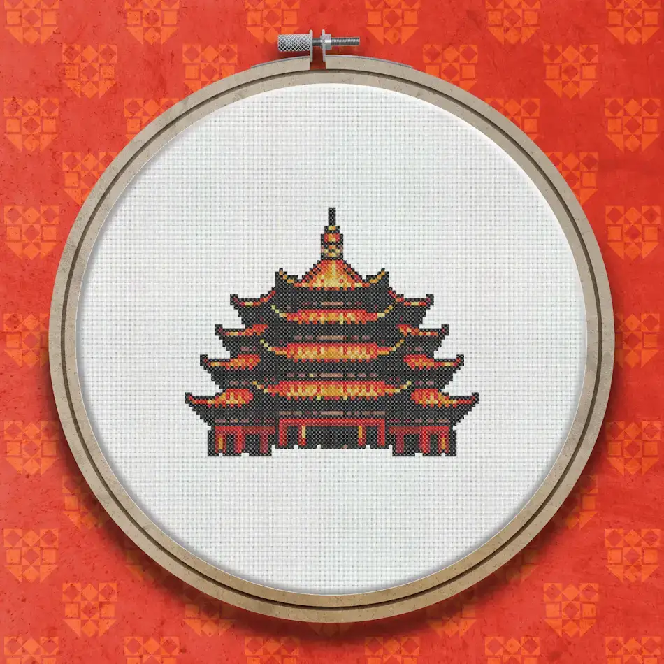 Cross stitch pattern of a multi-tiered Chinese pagoda in deep red and gold tones on a white background.