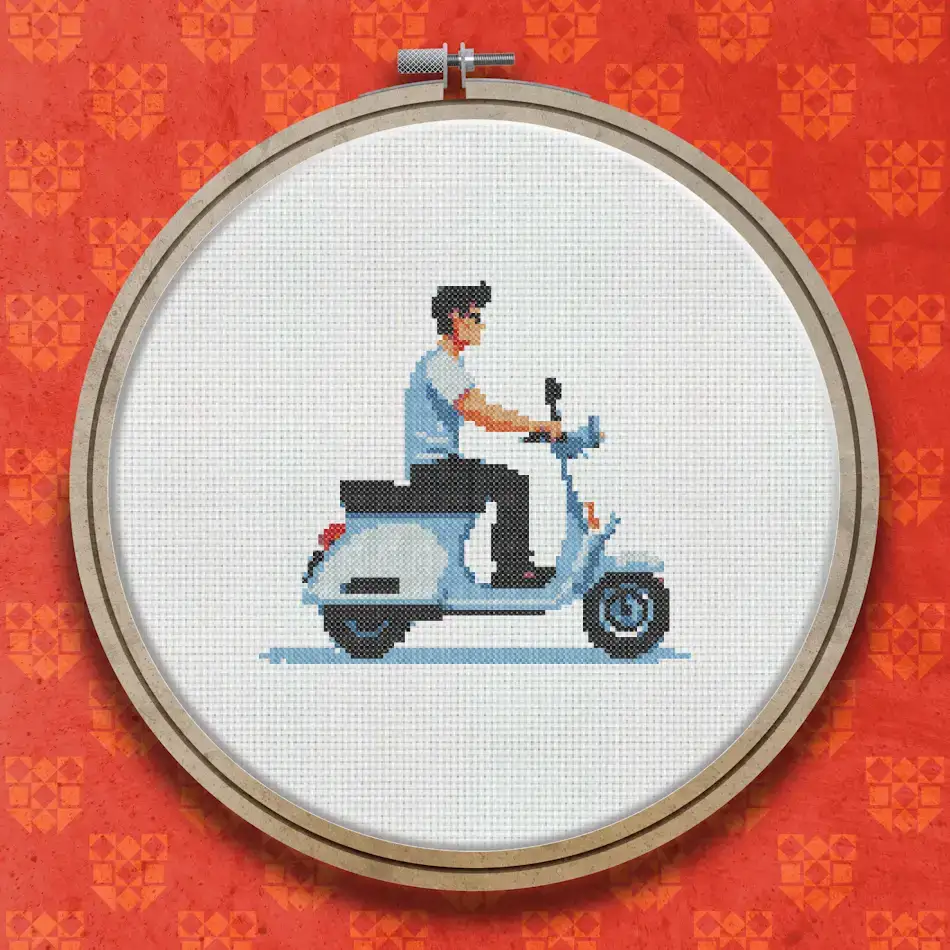 Pixel art cross stitch design of a man in a blue top riding a white classic scooter, shown from the side against a white background.