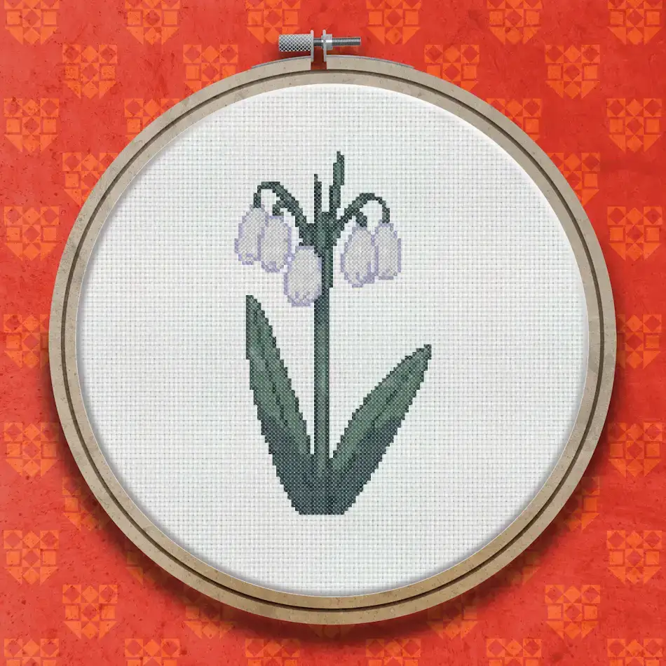 Cross stitch pattern of two white snowdrop flowers with drooping petals on slender green stems with long narrow leaves